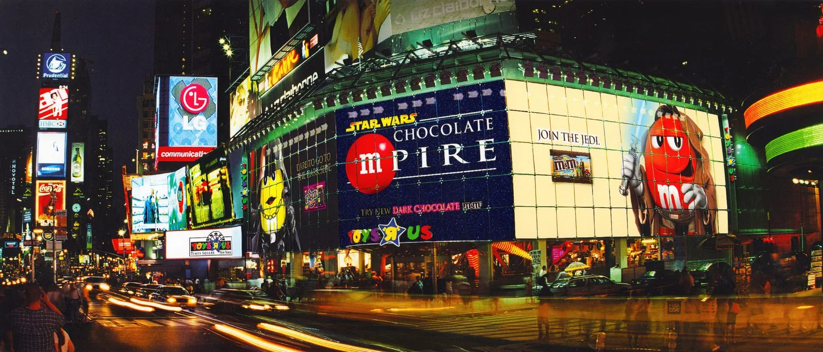 The same Star Wars Chocolate mPire billboard at night, fully lit over Times Square traffic, with Join the Jedi and Try New Dark Chocolate M&M's glowing