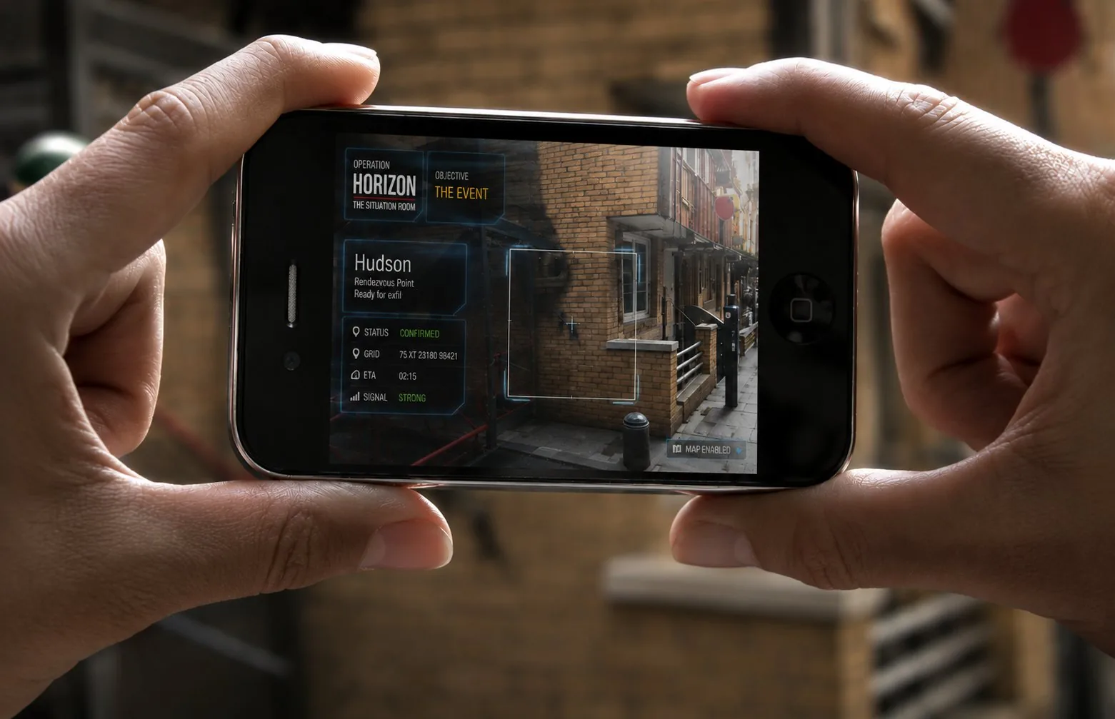 Operation Horizon augmented reality stunt: hands holding a phone scanning a Hudson dropzone with mission HUD overlay
