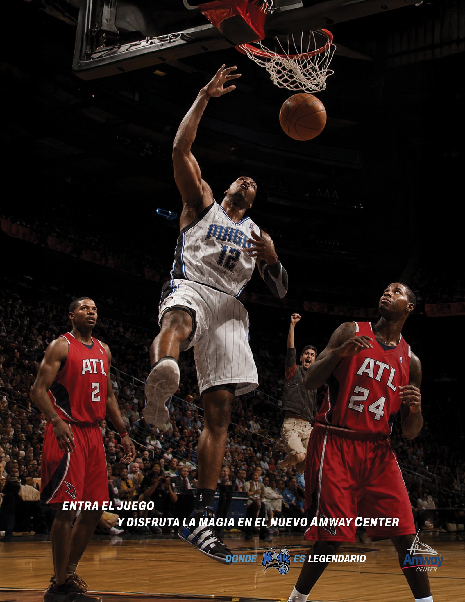 Spanish-language Orlando Magic print ad: a Magic player in the number 12 jersey dunks over two Atlanta defenders, under the line Entra el juego y disfruta la magia en el nuevo Amway Center