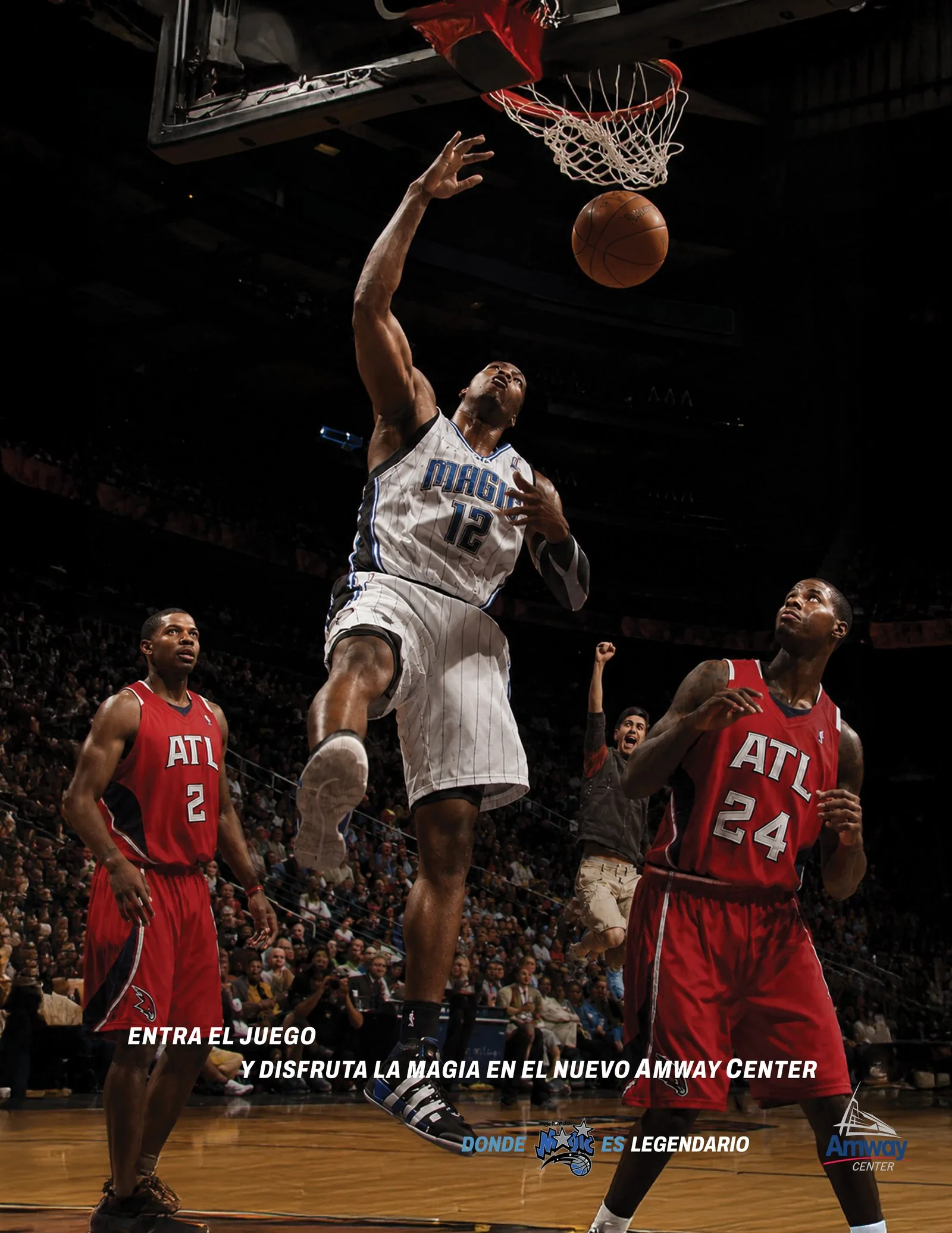 Spanish-language Orlando Magic print ad: a Magic player in the number 12 jersey dunks over two Atlanta defenders, under the line Entra el juego y disfruta la magia en el nuevo Amway Center