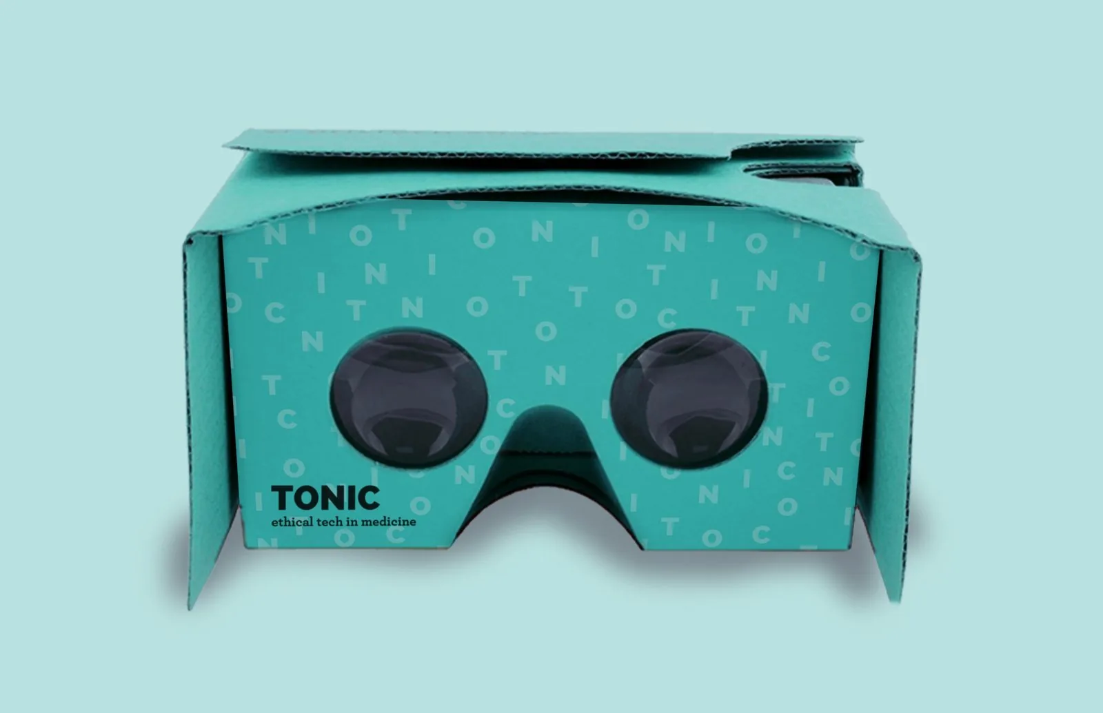TONIC-branded Google Cardboard VR viewer in teal with the scattered letter pattern and twin lenses