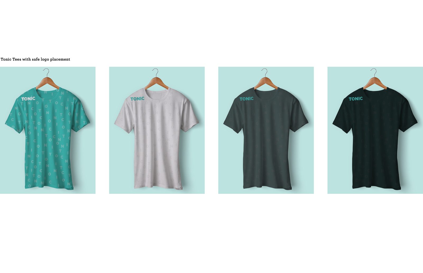 Four TONIC tees on wooden hangers in teal, white, charcoal and black, each with a small shoulder logo over the tonal letter pattern